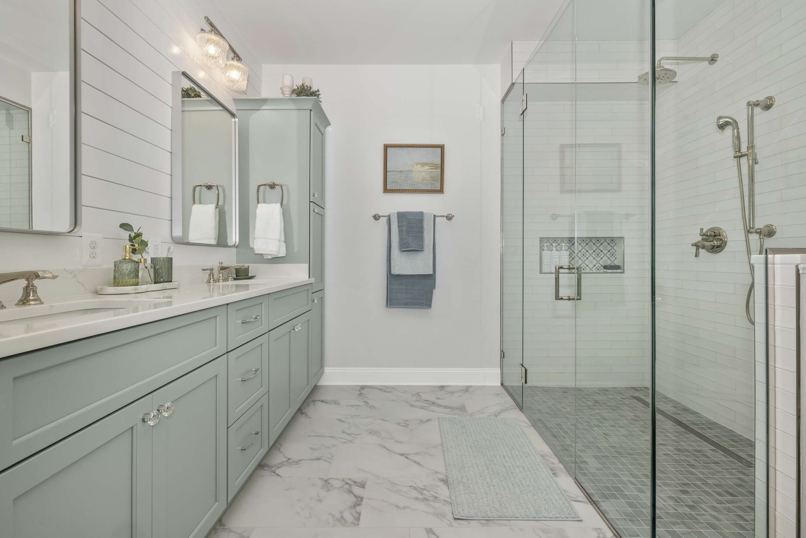 Large glass shower enclosure with handheld shower fixtures.